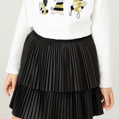 Saia preta plissada dupla em pessoa com camisola branca bordada com cães