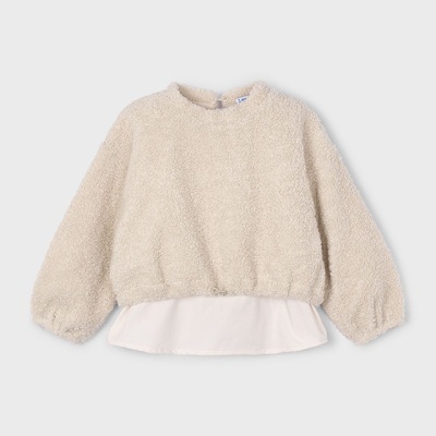 Camisola creme com bainha branca sobre fundo cinzento