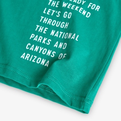 Parte inferior de t-shirt verde com texto branco impresso