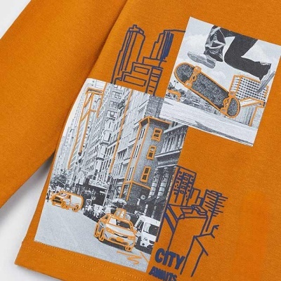 Camisola laranja com estampas urbanas em preto, branco e cinza, incluindo carro, edifícios, e skate.