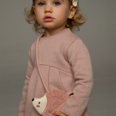 Menina vestindo camisola rosa com mala em forma de ouriço rosa