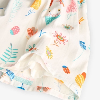 Tecido branco com padrão colorido de flores estilizadas e folhas