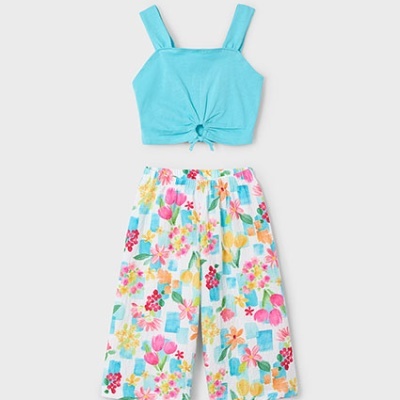 Conjunto de top azul claro e calças brancas com padrão floral colorido