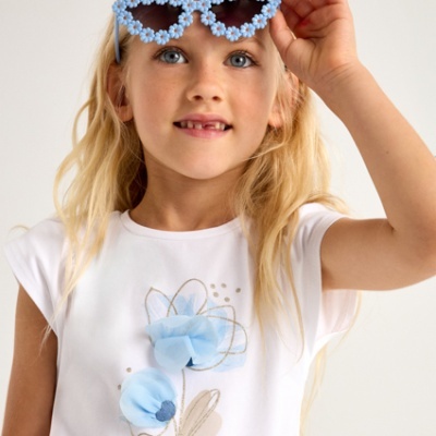 Menina com t-shirt branca com flor azul e óculos de sol decorativos azuis