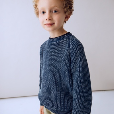 Criança com camisola azul e calças claras