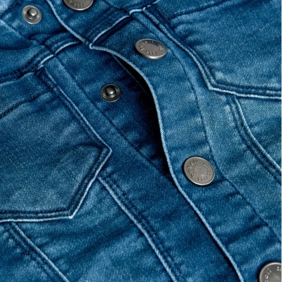 Tecido de ganga azul com botões metálicos prateados e costuras visíveis