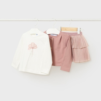 Conjunto de roupa infantil com camisola branca, casaco rosa e saia plissada rosa pendurado