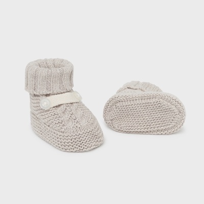 Botins de bebé em malha bege com padrão de trança e botão branco