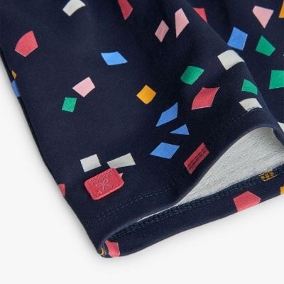 tecido azul escuro com padrão de quadrados coloridos e etiqueta rosa