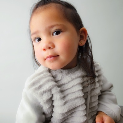 Criança com camisola cinzenta e fundo cinzento