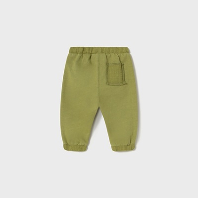 calças de bebé verdes com bolso quadrado num fundo cinzento claro