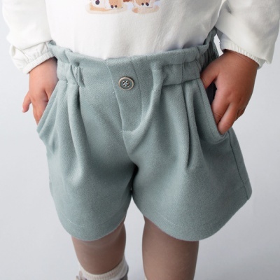 Calções de tecido verde-azulado com botão e elástico na cintura, em criança