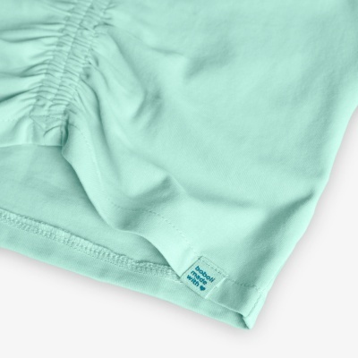 Peça de roupa feminina verde água com detalhe franzido e etiqueta Boboli Girls.