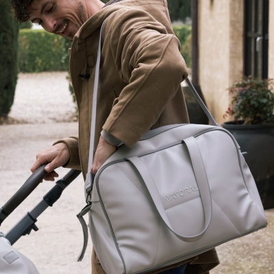 Homem transporta mala cinzenta clara MAYORAL ao ar livre