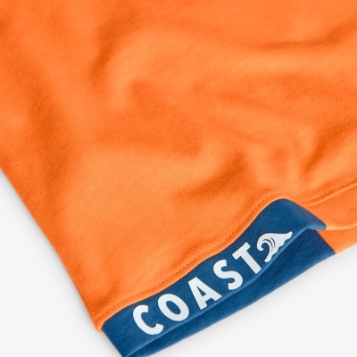 Pano laranja com punho azul e texto 'COAST' na borda
