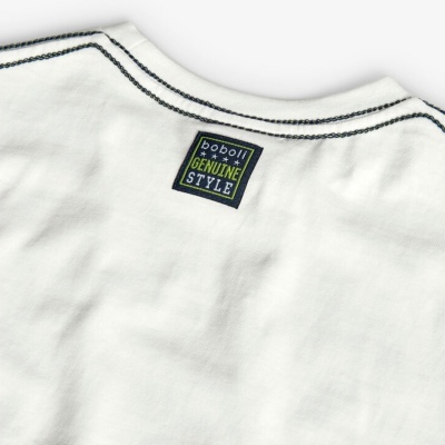 Peça de roupa branca com etiqueta azul e costura preta