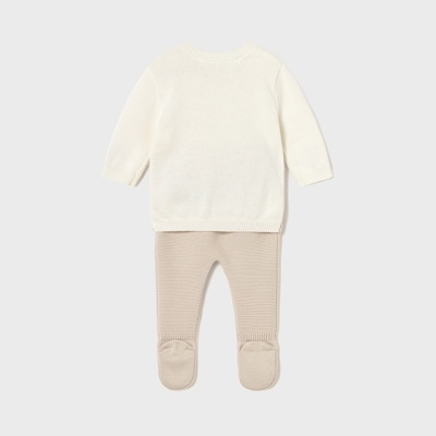 Conjunto de roupa de bebé branco e bege sobre fundo cinzento claro