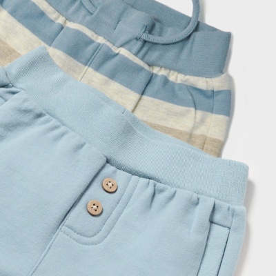 Duas peças de roupa infantil em tecido de malha, uma azul clara com botões e outra com riscas horizontais