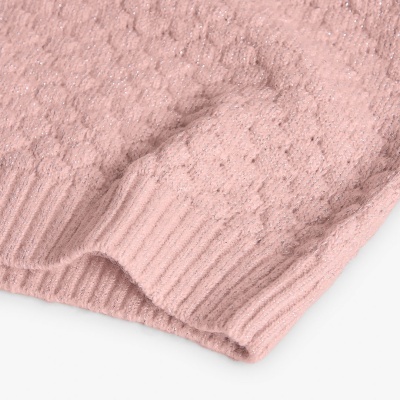 Peça de roupa de malha cor-de-rosa com padrão trançado e bainha canelada.