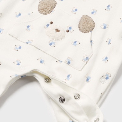 macacão de bebé branco com padrão de cães azuis e bege e aplicação de rosto de cão