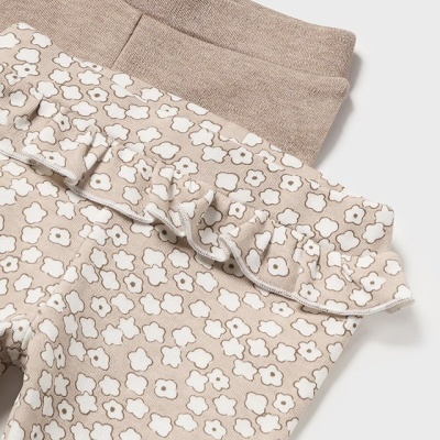 Calças de criança bege com padrão de flores brancas e babado no cós