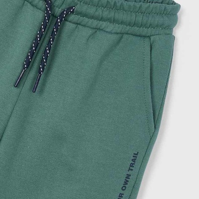 Calças de fato de treino verdes com cintura elástica e cordão preto e branco, texto 'MAKE YOUR OWN TRAIL'