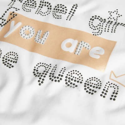 Detalhe de tecido branco com texto estampado e decorado com brilhantes