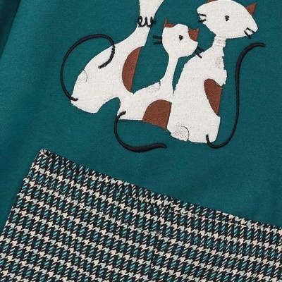 Peça de vestuário verde com gatos bordados e padrão pied-de-poule na base