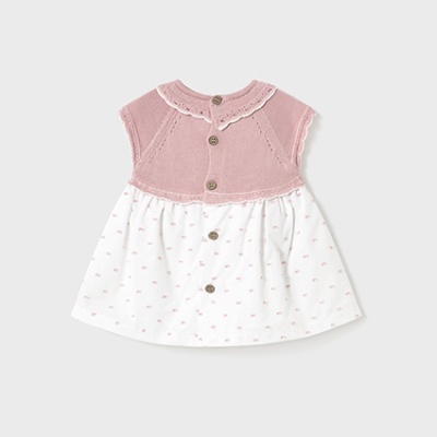 Vestido de bebé rosa e branco com texturas em malha e tecido, botões castanhos.