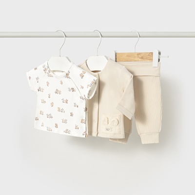 Conjunto de bebê com t-shirt estampada, camisa bege e calças caneladas penduradas