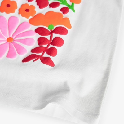 Tecido branco com padrão floral colorido em relevo.