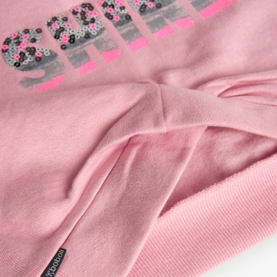 Peça de vestuário rosa com estampado e etiqueta preta