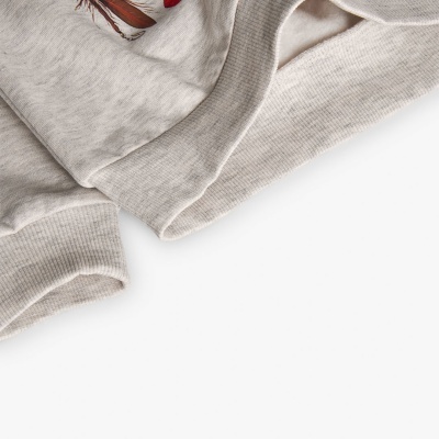 Pormenor de punhos canelados e bordado em roupa cinzenta clara