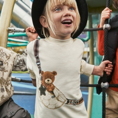 Camisola infantil bege com bolso transparente em forma de coração e ursinho de peluche