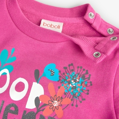 Camisola rosa forte com estampado de flores e botões de pressão no ombro.