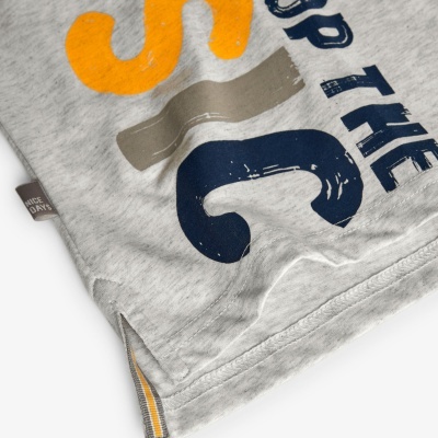 Detalhe de t-shirt cinza com estampas coloridas e etiqueta NICE DATE