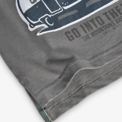 Parte inferior de t-shirt cinza com estampa azul e branca e texto parcial visível