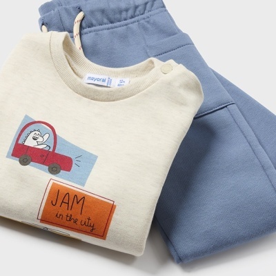 Conjunto de roupa infantil com t-shirt creme estampada e calças de ganga azul clara.