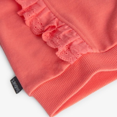 Detalhe de blusa coral com folho de renda e etiqueta Boboli