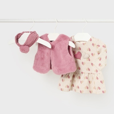 Conjunto de roupa para bebé com colete rosa peludo, vestido bege com estampado cor-de-rosa e branco, e faixa de cabeça rosa com pompom.