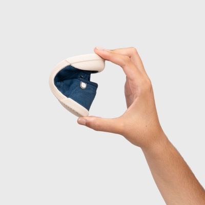 Calçado infantil azul flexível segurado por mão