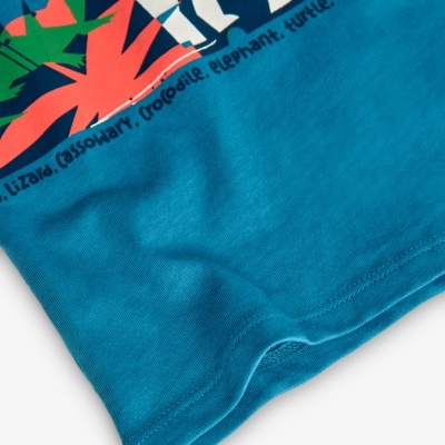 Parte inferior de t-shirt azul com costura e estampado colorido com nomes de animais