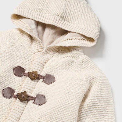 Casaco de malha creme com capuz e pompom, fecho com botões de madeira