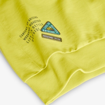 Peça de roupa amarela com etiquetas em padrão triangular e texto impresso