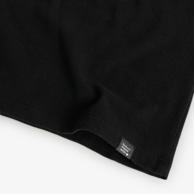 Pormenor de peça de roupa preta com etiqueta benetton born to win