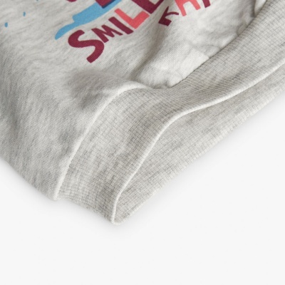 Parte de roupa cinza com texto parcial impresso em vermelho e azul