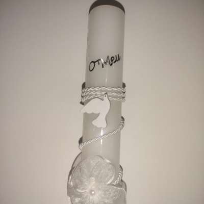 Vela branca alta com decoração de cordão, flor de tecido e pendente de pássaro.