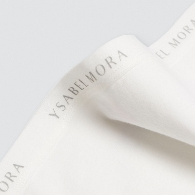 Pano branco com nome Ysabel Mora na borda