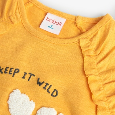 Camisola amarela para criança com texto 'KEEP IT WILD' e folhos no ombro