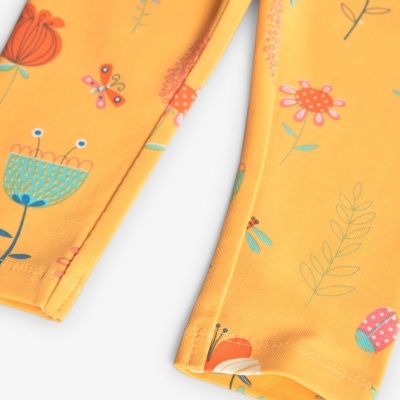 Detalhe de tecido amarelo com flores e insetos coloridos